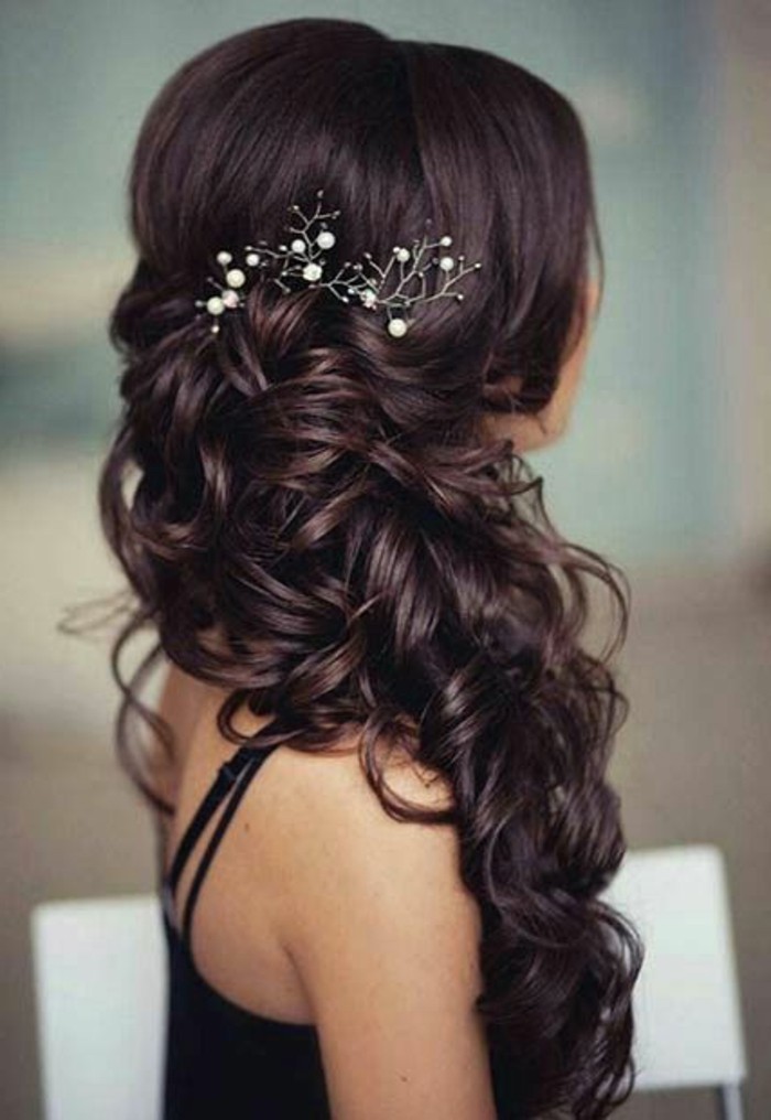 long black curly hair, pearl hair accessory, short prom hairstyles, woman wearing a black top