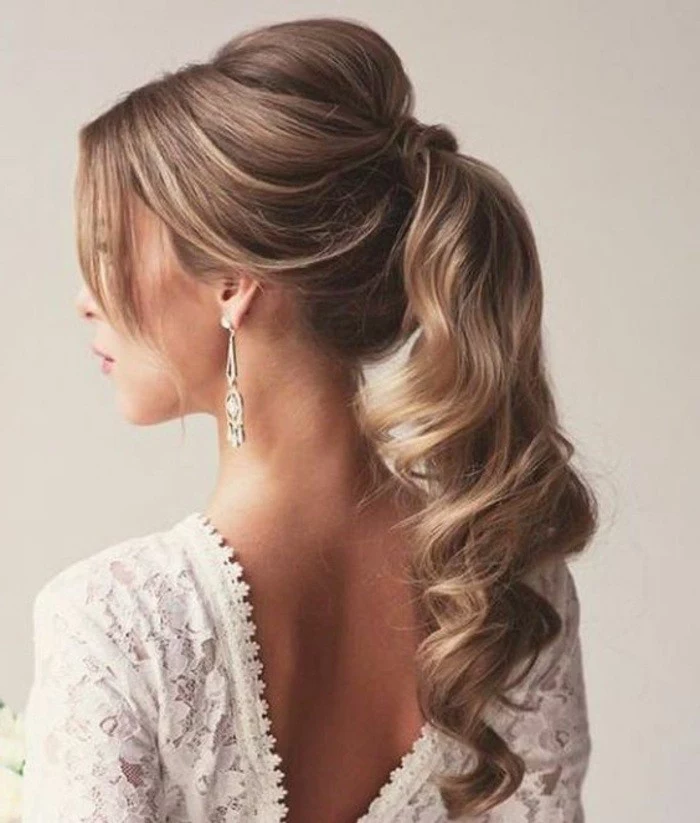 white lace dress, blonde hair, in a high wavy ponytail, wedding hairstyles updo, hanging earrings