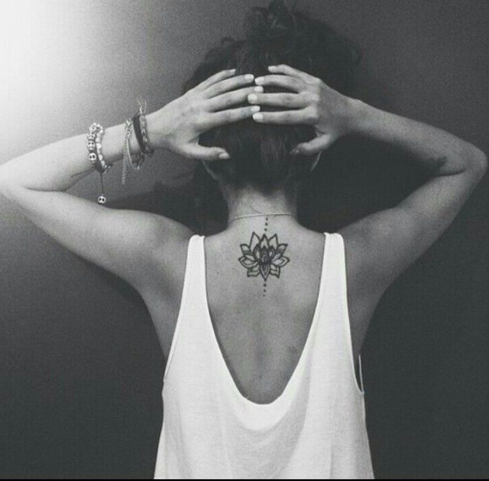 mandala tattoo design, lotus flower, back tattoo, white top, grey background, hair in a messy bun