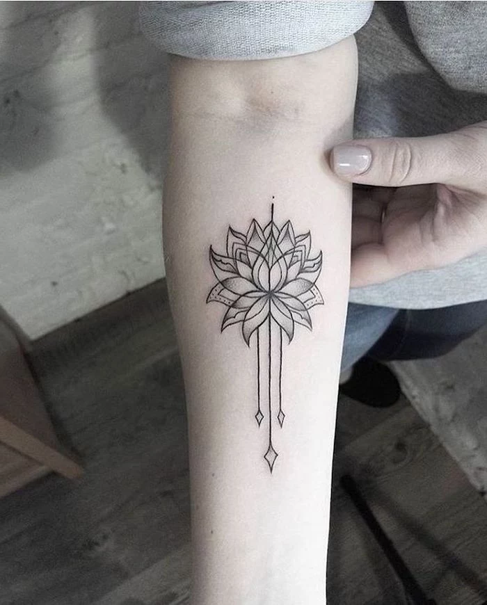 lotus flower, mandala meaning, forearm tattoo, wooden floor, grey blouse