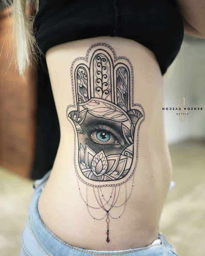 what does mandala mean, hamsa hand tattoo, jeans and black top, blonde hair