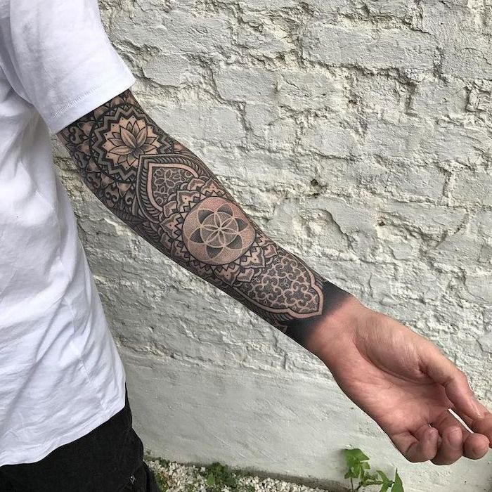 white brick wall, sleeve tattoo, white shirt, what does mandala mean