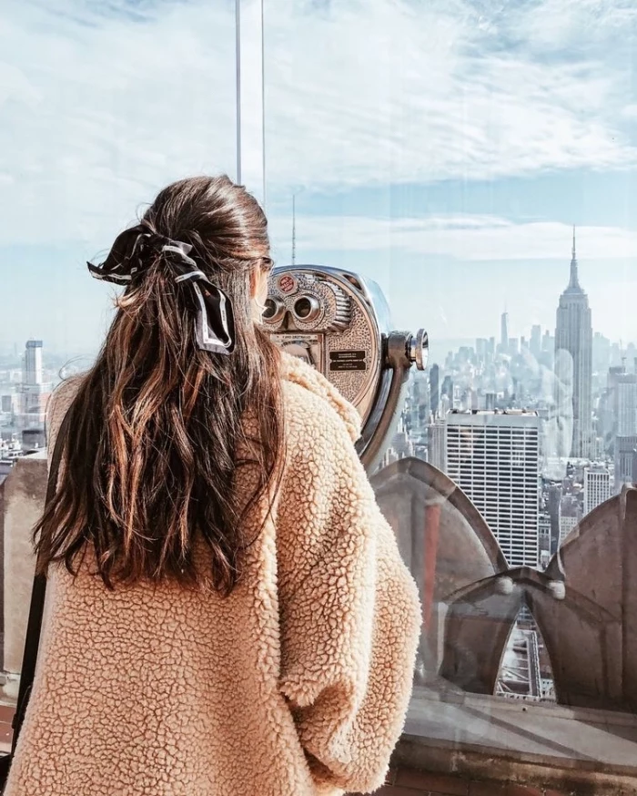new york city skyline, long brown wavy hair, with highlights, bridesmaid updos, girl wearing an orange jacket