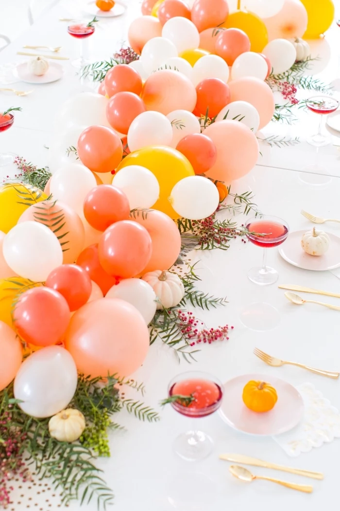 orange white and yellow balloons, table runner, centerpiece ideas, on a white table, wine glasses