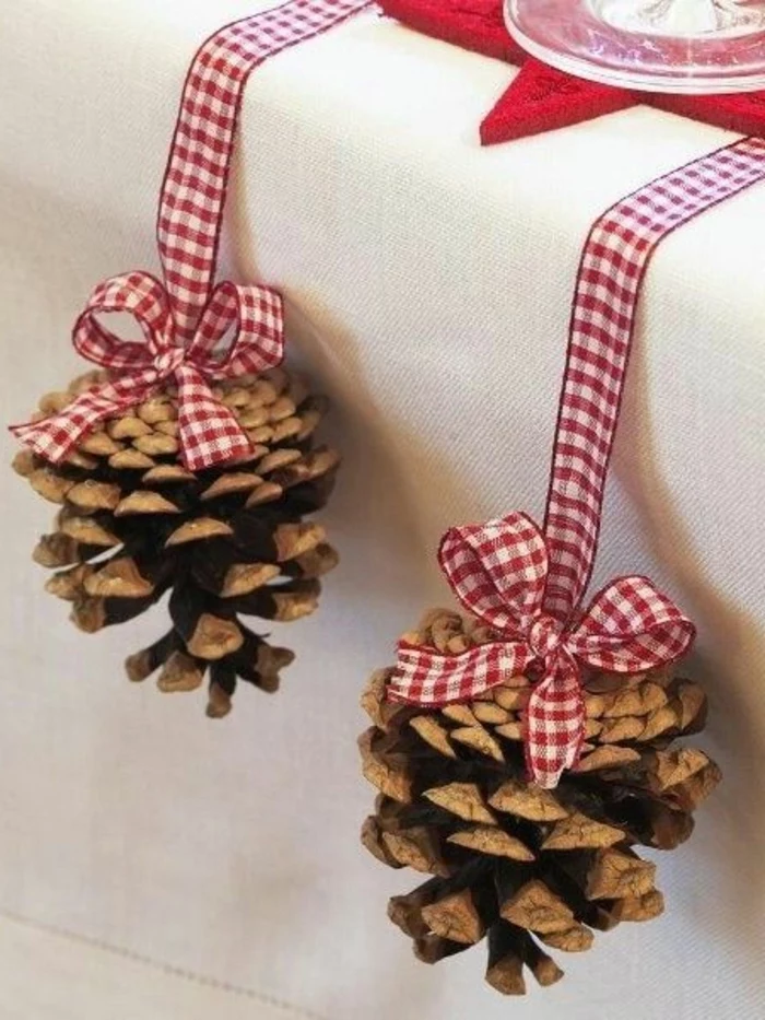 two pine cones, hanging from the table, tied with red and white, plaid ribbons, center table decor