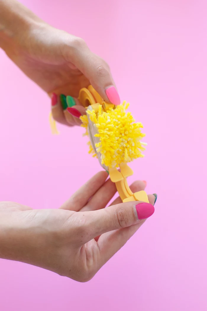 pink background, diy anniversary gifts for him, yellow yarn, pom pom maker, step by step, diy tutorial