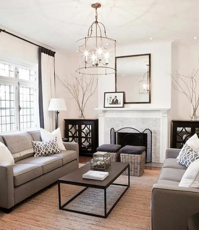 gray color schemes, mirror above the fireplace, black metal coffee table, grey sofas, tall ceiling