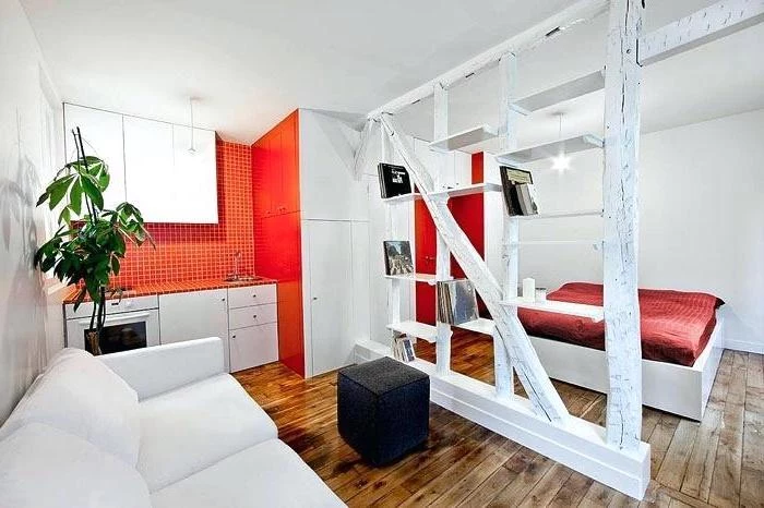 orange accent kitchen wall, wooden floor, small living room layout, wooden bookshelf, room divider, white sofa