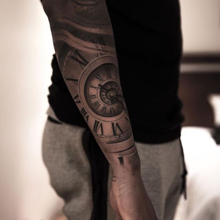 clock side arm tattoo, birthday tattoos in roman numerals, black shirt, grey trousers