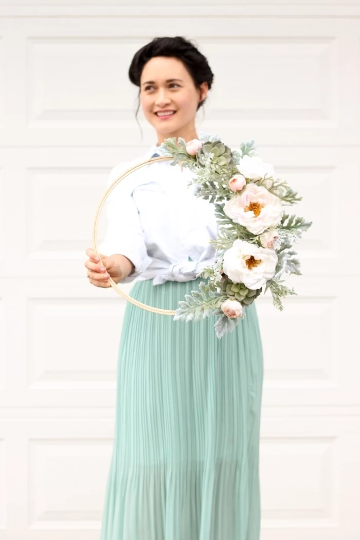 woman wearing a turquoise skirt, white shirt, holding a flower wreath, bedroom wall decor ideas