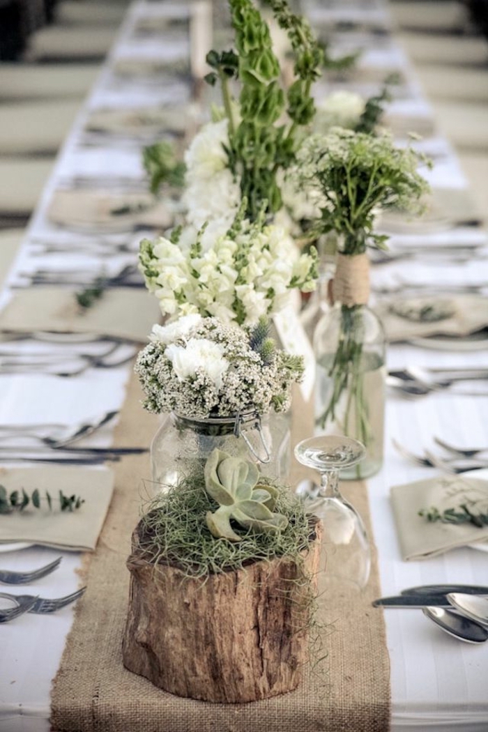 dining table decor ideas, rustic style, glass jars and vases, full of white flowers, wooden block with moss