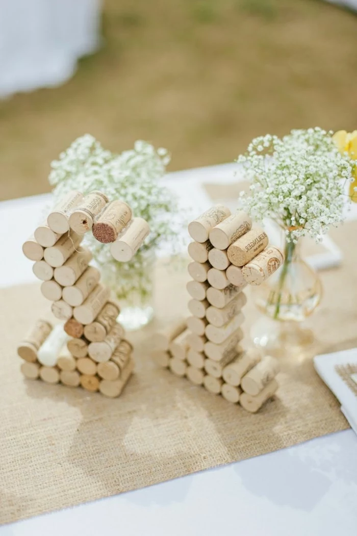 table numbers, made out of cork screws, simple centerpieces, baby's breath, small bouquets