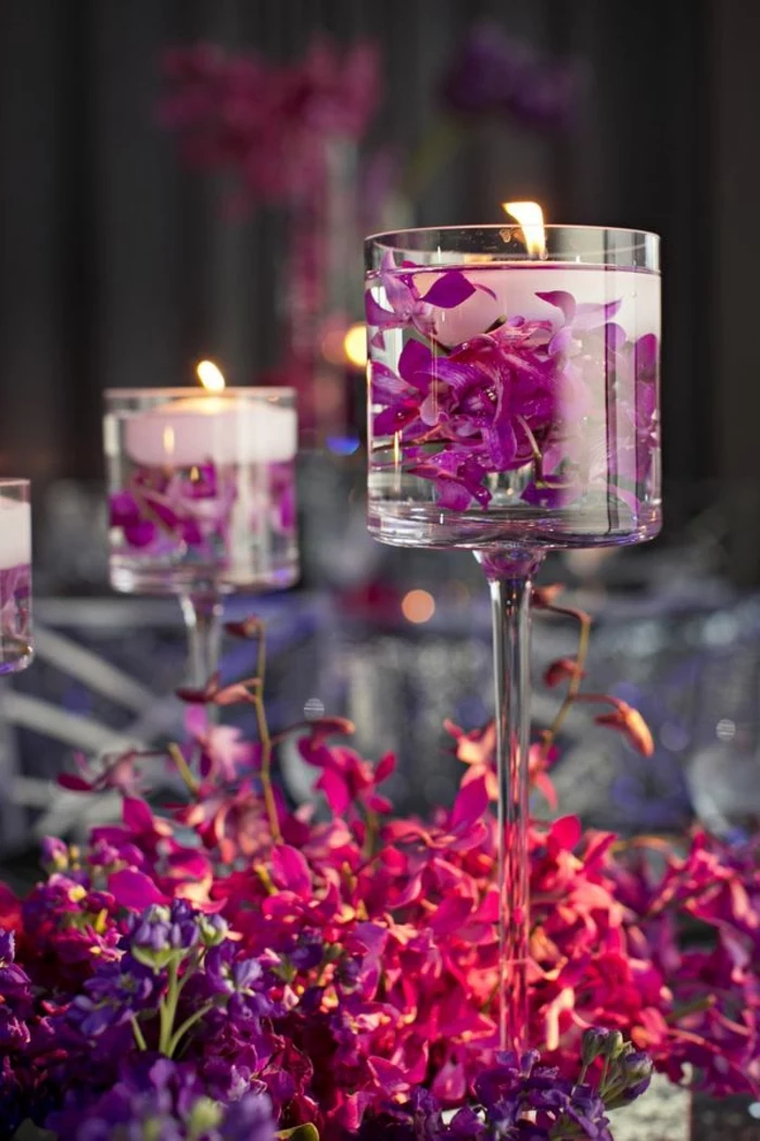 tall glass vases, filled with water, flower petals and candles, spring flower arrangements, pink and purple flowers
