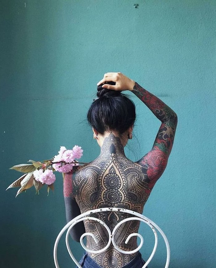 blue background, white metal chair, mandala tattoo, whole back tattoo, sleeve tattoos