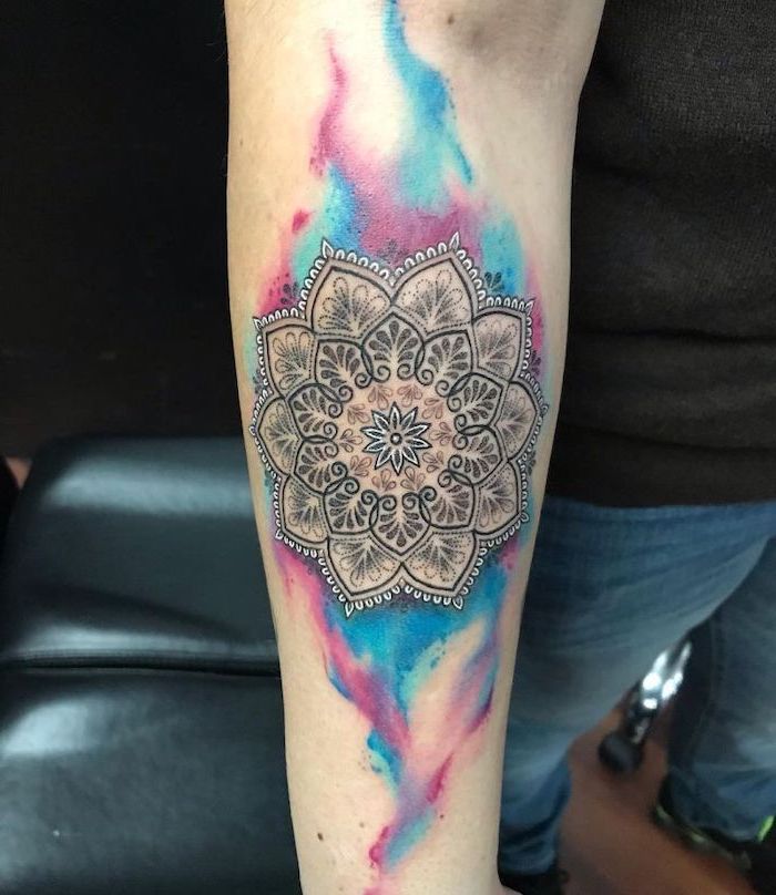 mandala wrist tattoo, watercolour forearm tattoo, jeans and a black shirt