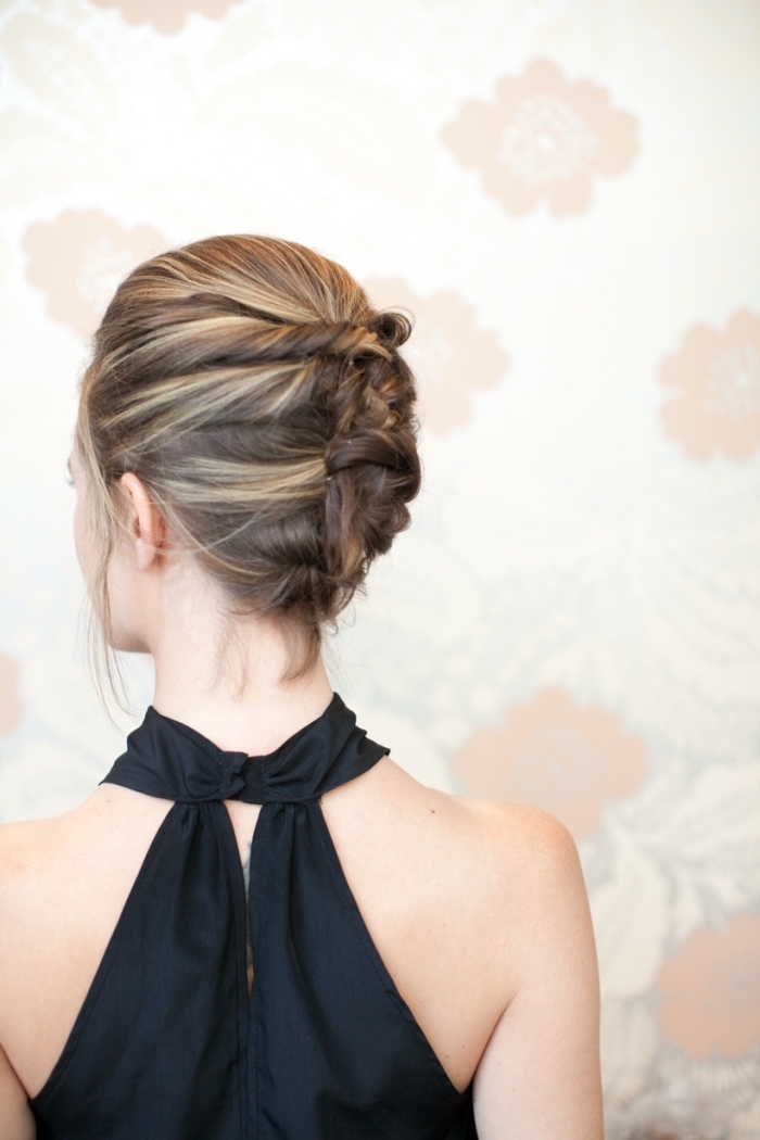 woman wearing a black top, prom hairstyles half up half down, brown hair, with highlights, in a low updo