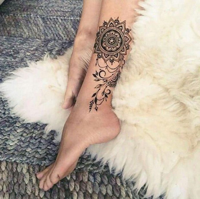 small mandala tattoo, white furry blanket, leg tattoo, colourful carpet