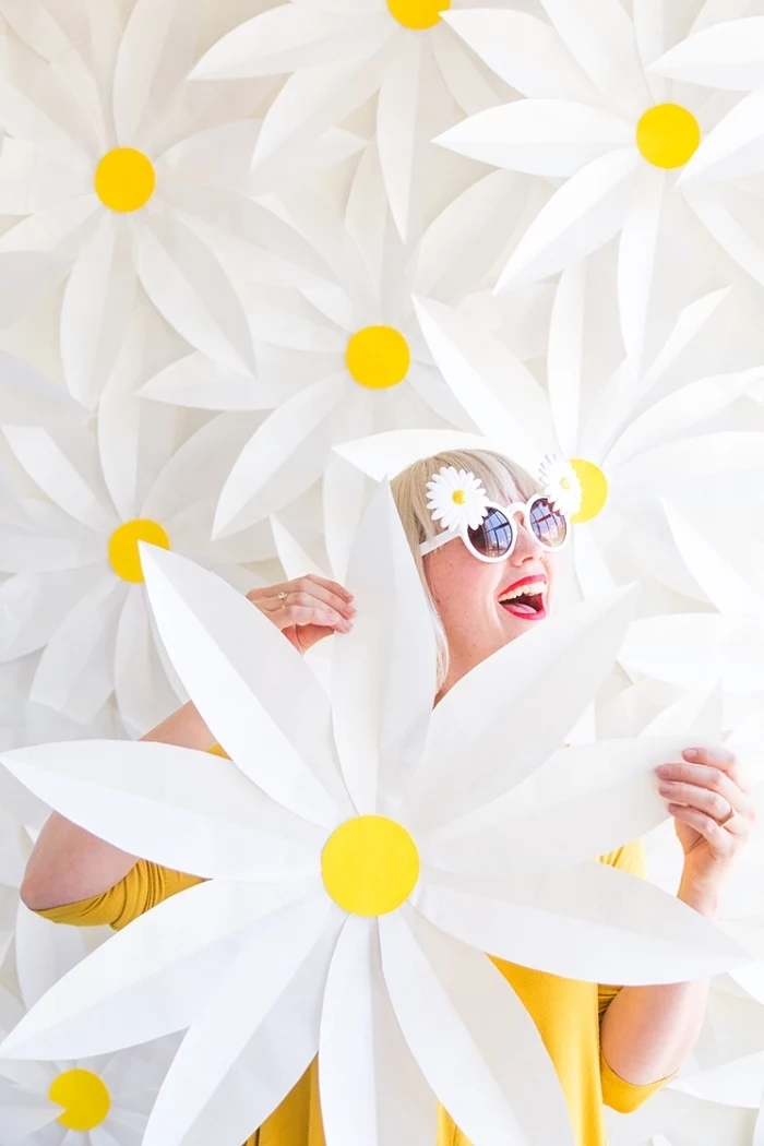 lots of white daisies, attached to a wall, woman holding a daisy, wall decor ideas, daisy sunglasses