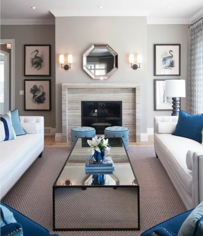 white sofas, blue printed throw pillows, blue ottomans and armchairs, grey living room furniture, glass coffee table