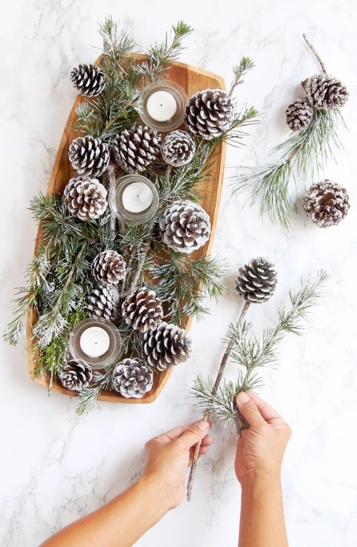 wooden tray, full of pine cones, candles and pine tree branches, fall flower arrangements, marble countertop