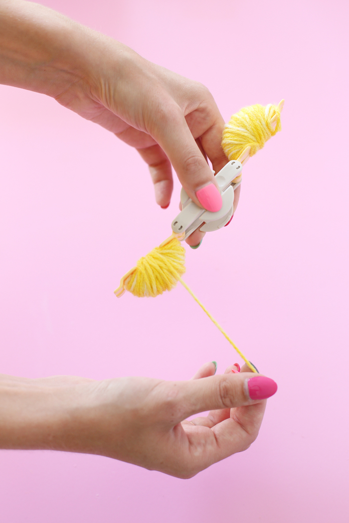 pom pom maker, yellow yarn, diy anniversary gifts for him, pink background, pink nail polish