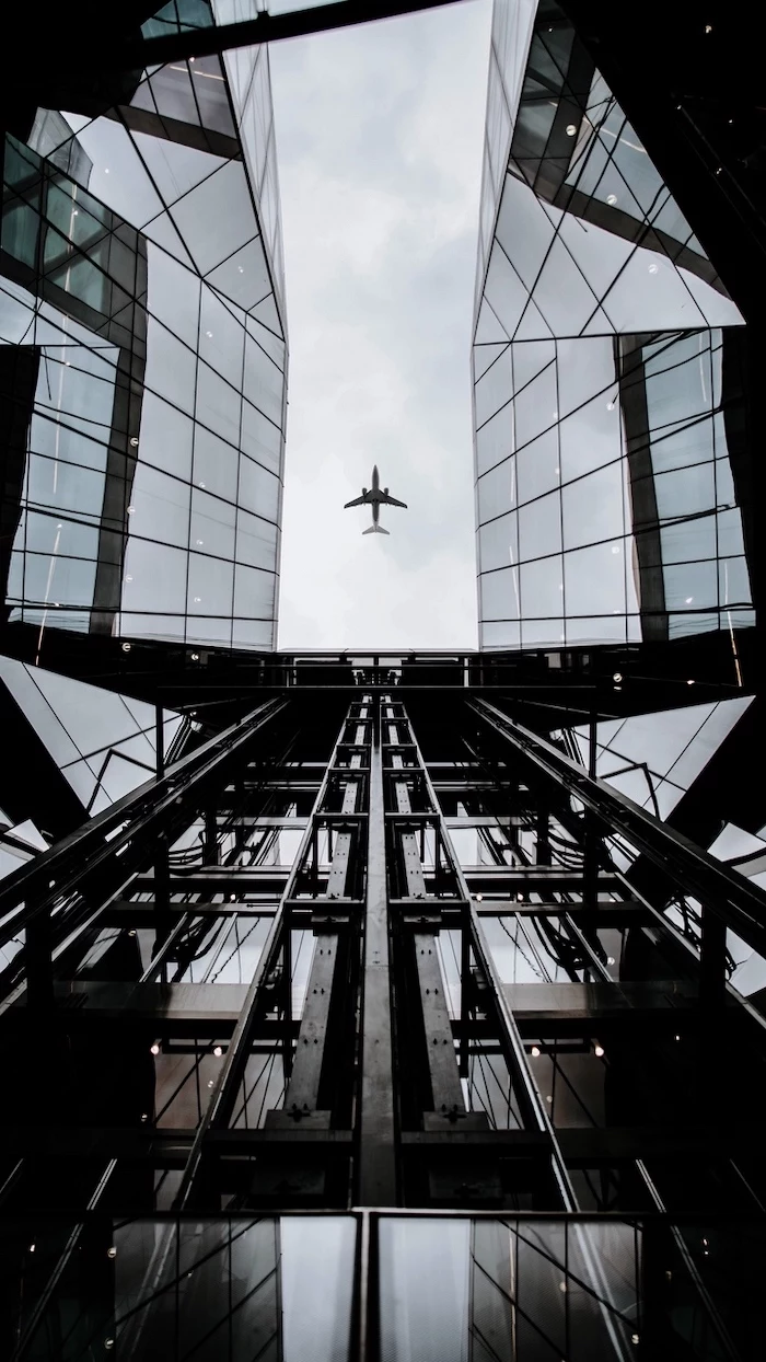 airplane in the sky, flying over a glass building, cute backgrounds