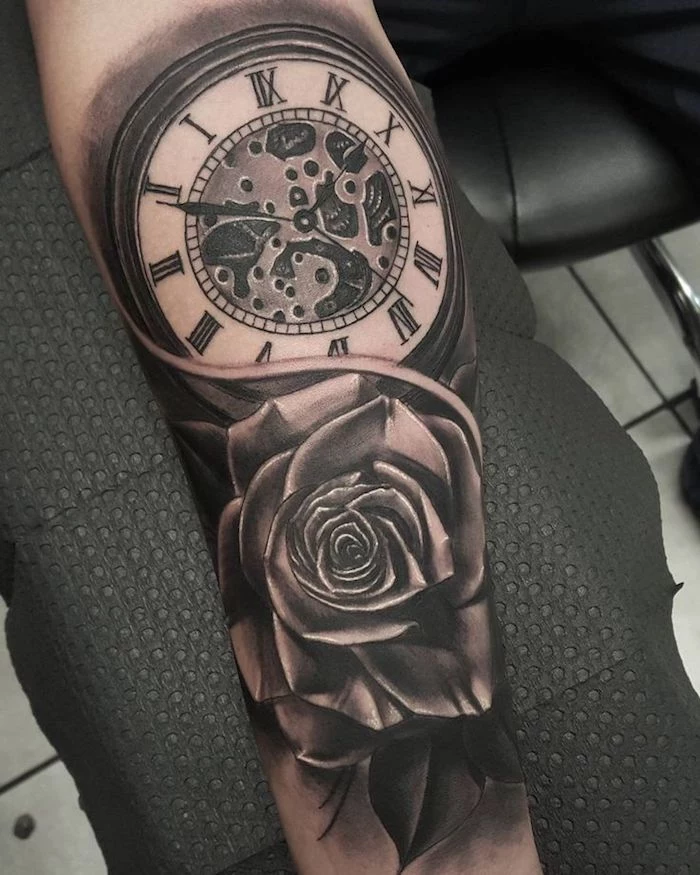 large watch with roman numerals, rose underneath, small tattoos for men, black paper
