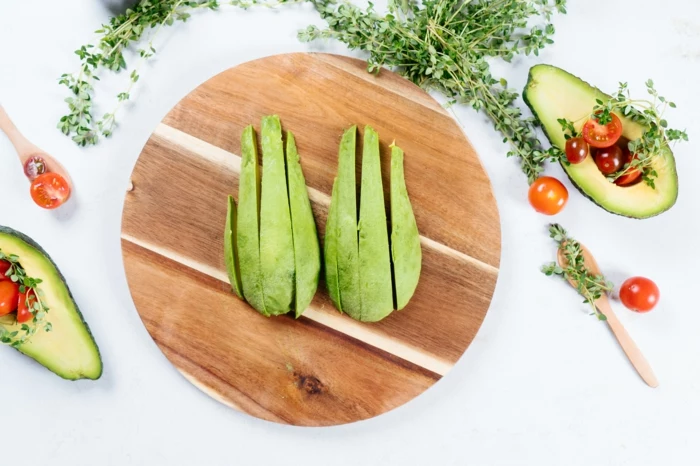 avocado slices, placed on round wooden cutting board, avocado fries recipe, cherry tomatoes around them