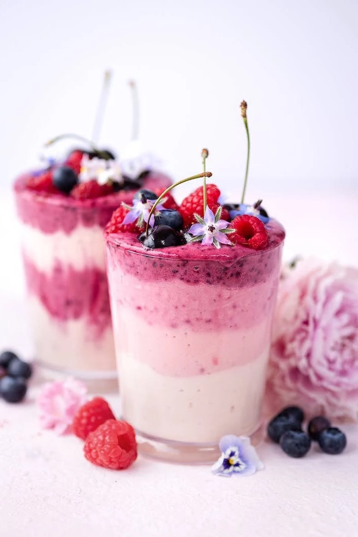 layered smoothie, how to make a smoothie, berries on top, flowers scattered around