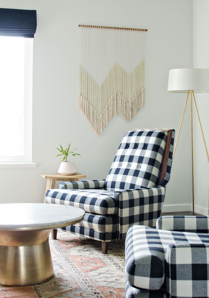 large macrame wall hanging, black and white armchairs, metal brass table, printed rug