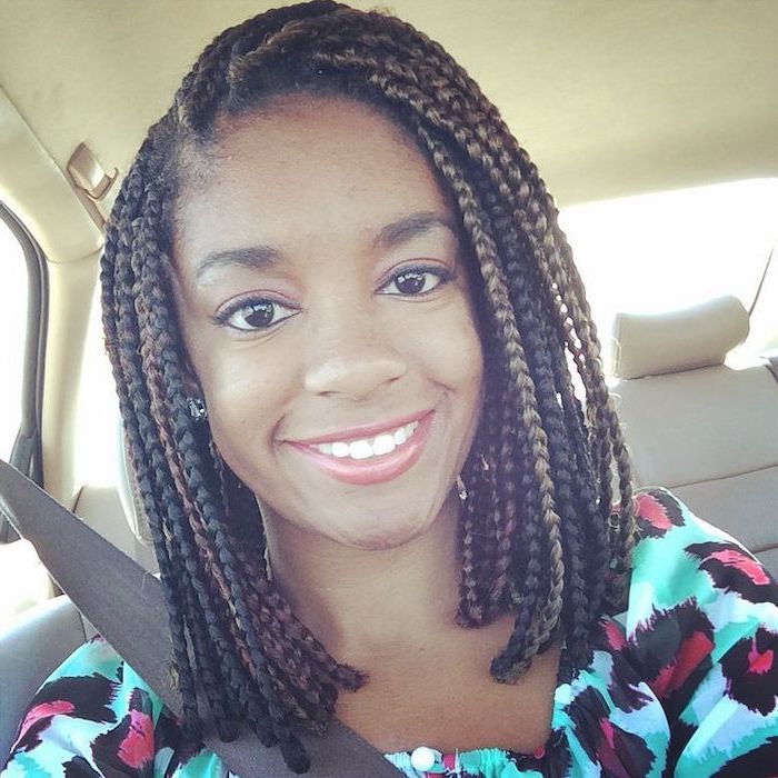 woman smiling, sitting in a car, pictures of braids, short black hair, printed blouse