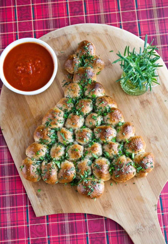christmas tree shaped bread bites, tomato sauce in a white bowl, on a wooden board, vegetarian appetizer recipes