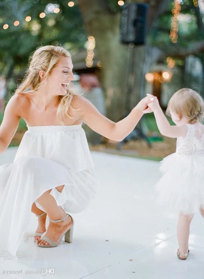 bride and toddler flower girl dancing, white lace and tulle dress, dresses for girls, white tiled floor