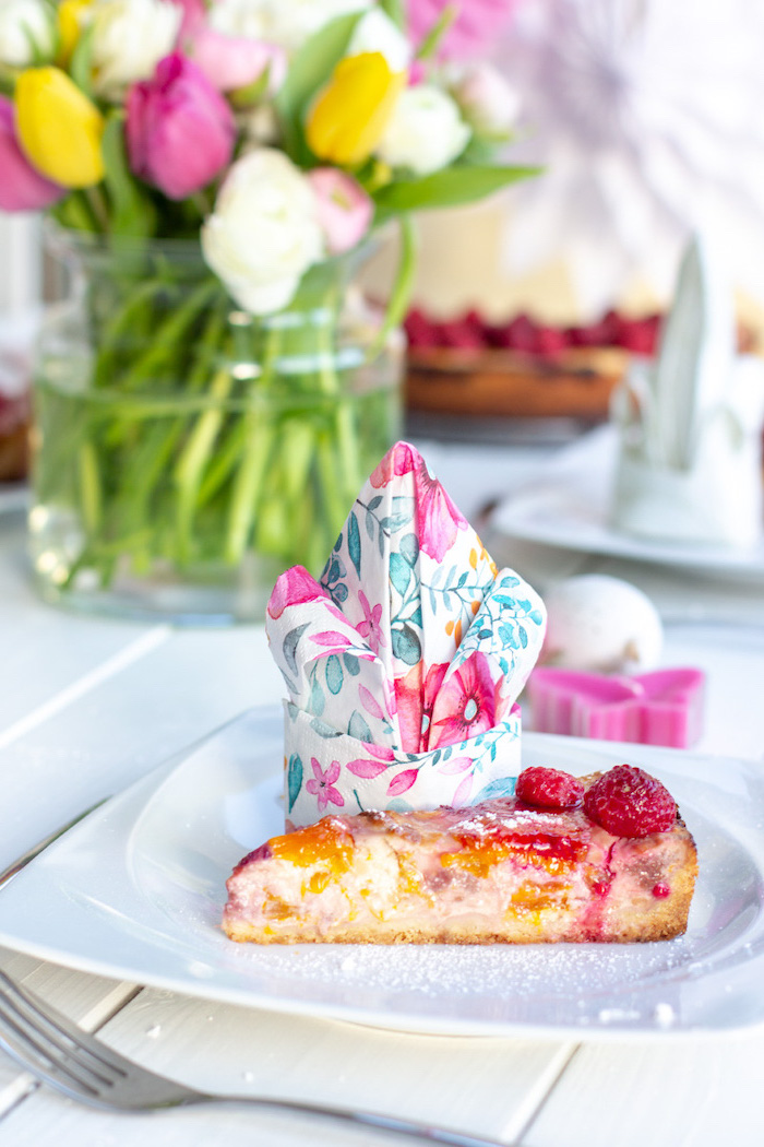 floral napkin, in a white plate, strawberry cheesecake piece, christmas napkin folding