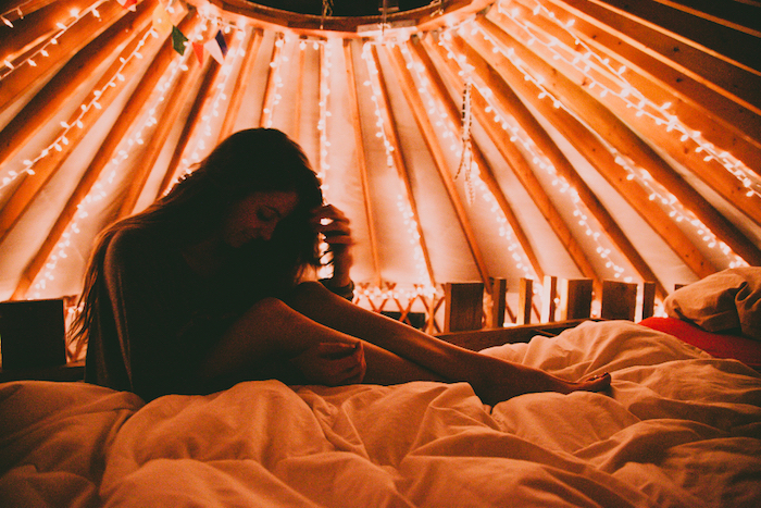 tumblr iphone backgrounds, set up tent, woman sitting on a bed, fairy lights