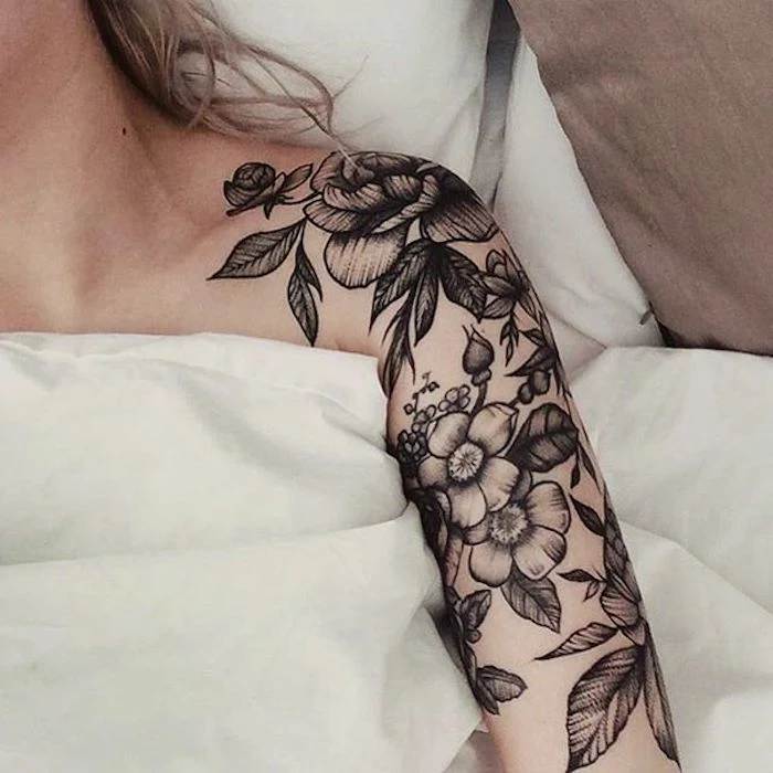 small meaningful tattoos, white bed linen, blonde hair, flower shoulder tattoo