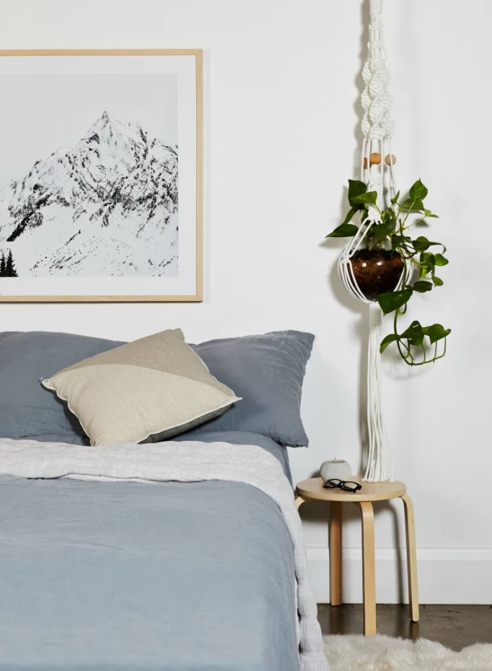 plant hanger, potted plants, blue bed linen, framed black and white photo, macrame tutorial