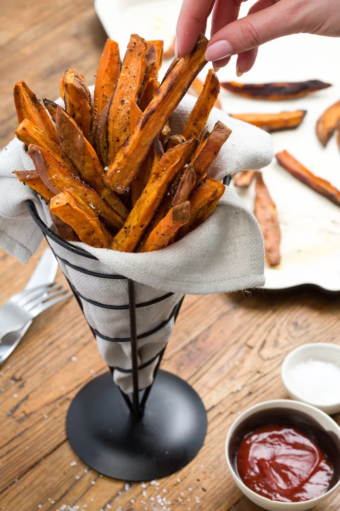 sweet potato, french fries, in a metal cone, veggie appetizers, ketchup in a white bowl