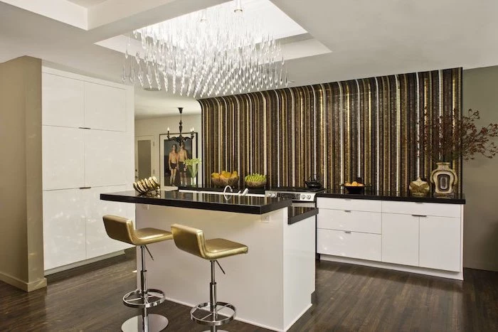 dark wooden floor, gold leather bar stools, large kitchen island with seating, accent wall in gold and black