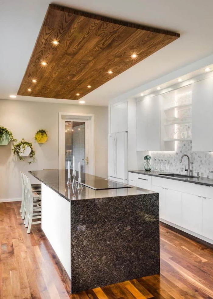 wooden floor, granite countertops, tiled backsplash, large kitchen island with seating, wooden block on the ceiling