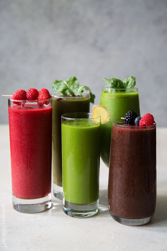 tall glasses, filled with colourful smoothies, strawberry banana smoothie, made with different ingredients