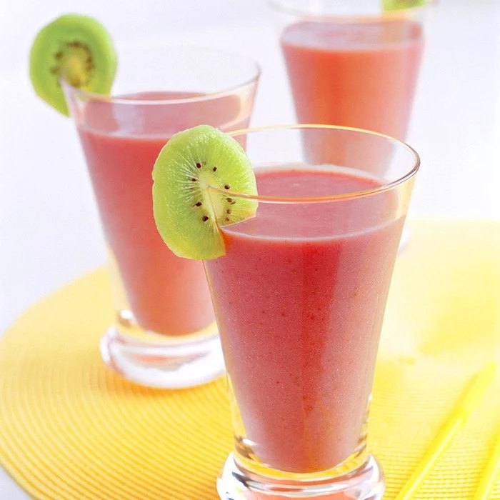 pink smoothies, in tall glasses, kiwi slices on the rim, how to make a fruit smoothie, yellow mat