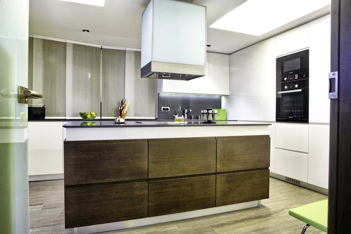 wooden drawers, white walls, white cabinets, large kitchen island with seating, wooden floor