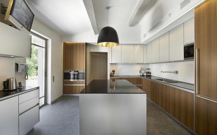 granite tiled floor, wooden cabinets and drawers, black countertops, narrow kitchen island