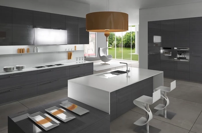 kitchen island cabinets, grey cabinets and drawers, white bar stools, tiled floor, hanging orange lamp