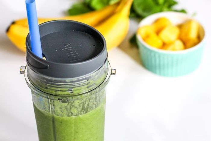 breakfast smoothie recipes, in a glass bottle, with blue straw, mango and banana