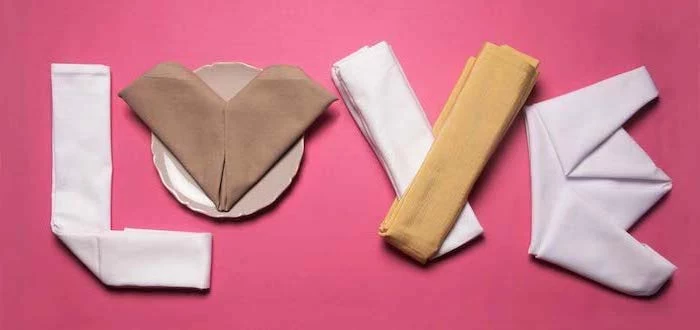 pink background, fancy napkin folding, love written with napkins
