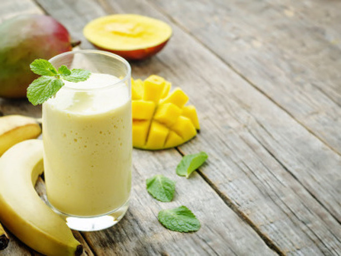 mango slices, bananas on the side, mint leaves, breakfast smoothie recipes, on a wooden table