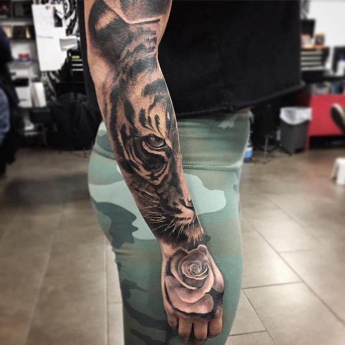 tiger head, rose underneath, forearm sleeve tattoo, navy tights, black top, riled floor