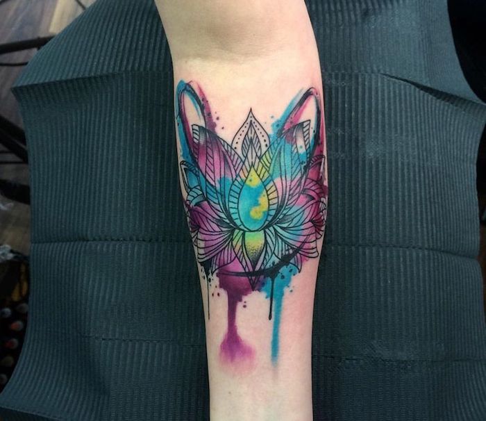 watercolour lotus flower, forearm sleeve tattoo, hand on black paper